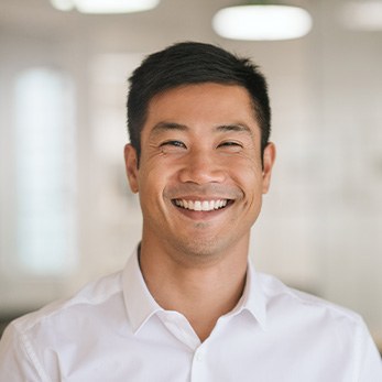 Man in white button-up shirt smiling