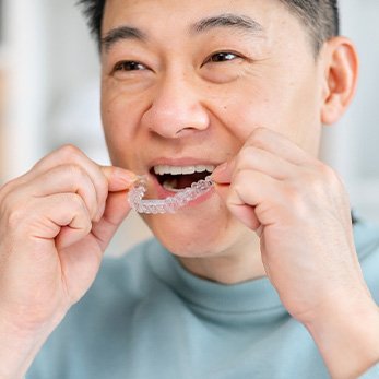 Patient putting on clear aligner