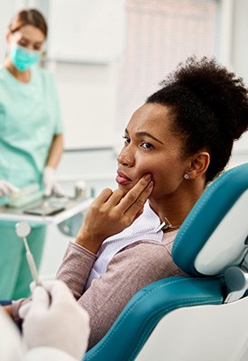 Patient with toothache looking at dentist in treatment chair