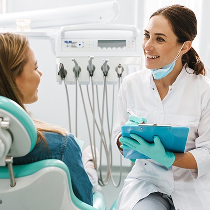 Dentist smiling at patient in treatment chair